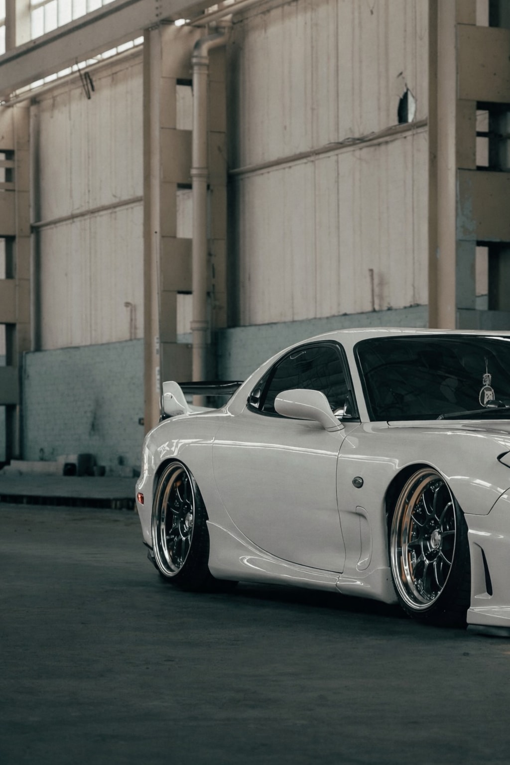 Side crop of the RX-7 showing the low body line and polished-lip wheels